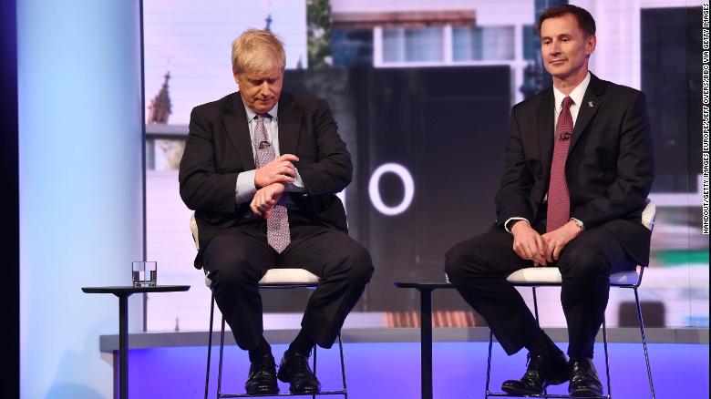 Boris Johnson, sitting next to UK Foreign Secretary Jeremy Hunt, checks his watch during the Conservative Leadership debate on June 18.