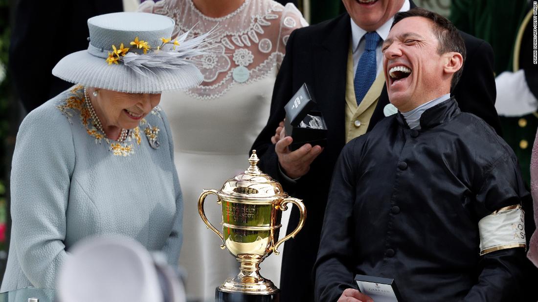 Britain&#39;s Queen Elizabeth II presents jockey Frankie Dettori with the Gold Cup after his second straight win on Stradivarius.