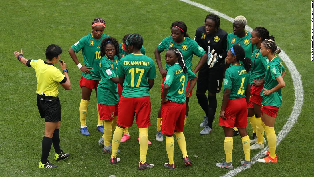 Cameroon players confront referee Qin Liang following England&#39;s second goal for Ellen White which is allowed after a VAR decision.