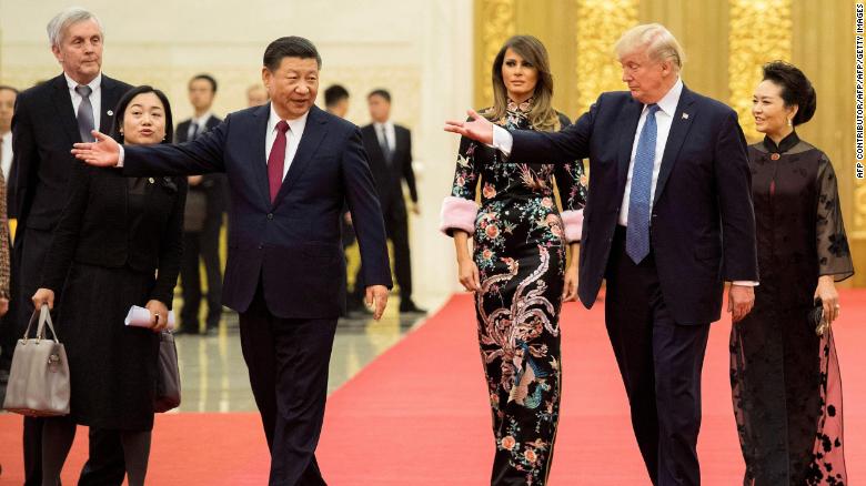 US President Donald Trump gestures toward China&#39;s President Xi Jinping, as US First Lady Melania Trump and Xi&#39;s wife Peng Liyuan look on in the Great Hall of the People in Beijing on November 9, 2017.