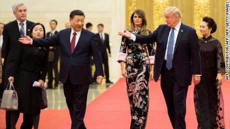 US President Donald Trump gestures toward China&#39;s President Xi Jinping, as US First Lady Melania Trump and Xi&#39;s wife Peng Liyuan look on in the Great Hall of the People in Beijing on November 9, 2017.