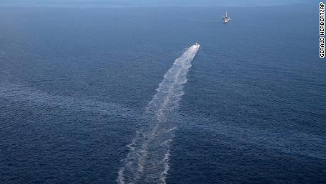 In this March 31, 2015, aerial photo, the wake of a supply vessel heading toward a working platform crosses over an oil sheen drifting from the site of the former Taylor Energy oil rig in the Gulf of Mexico, off Louisiana.
