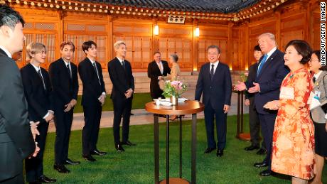 President Donald Trump talks with South Korean K-pop band EXO as South Korean President Moon Jae-in looks on at the presidential Blue House in Seoul on Saturday, June 29.