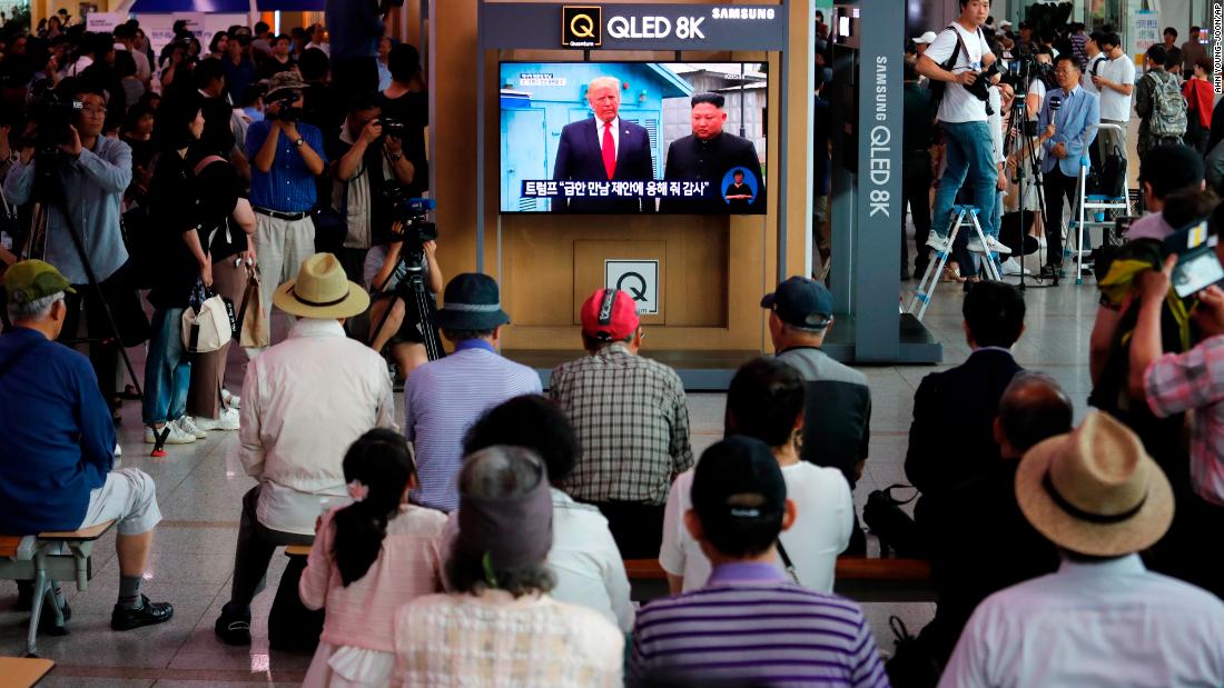 People at the Seoul Railway Station watch a news program on a TV screen showing Trump and Kim at the border village of Panmunjom on June 30. 