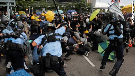 Riot police try to disperse protesters on the anniversary of Hong Kong&#39;s handover to China.