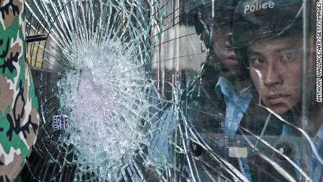 Police standing inside the government headquarters look at protesters who tried to smash their way into the building.