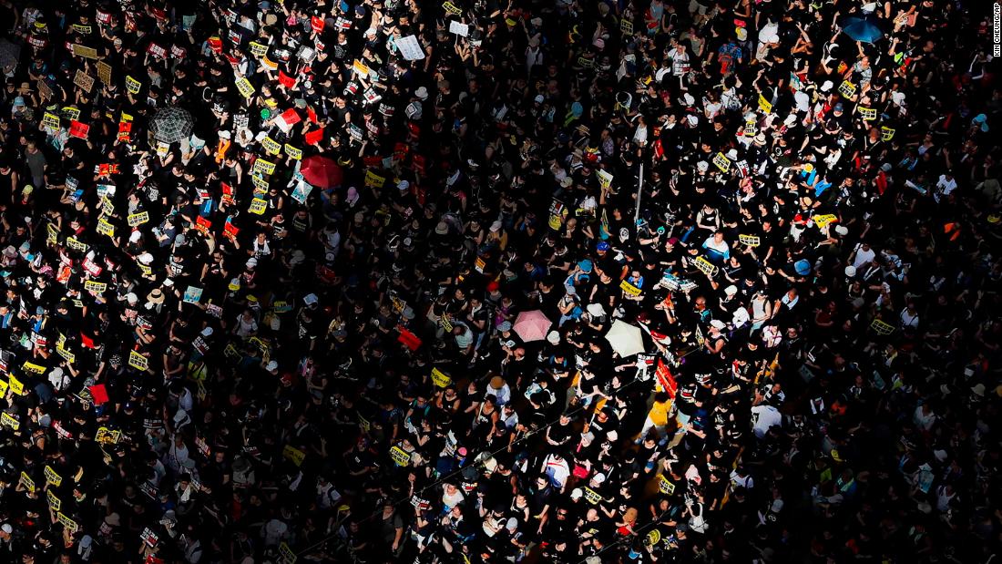 Columns of sunlight are cast on a crowd during the march on July 1.