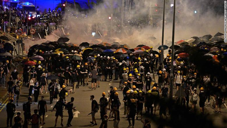 Hong Kong police fire tear gas as protesters flee