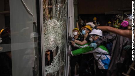 Protesters smash glass doors and windows to break into the parliament chamber of Legislative Council Complex on July 1.