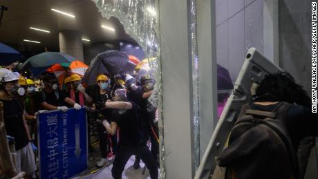 This picture taken on July 1, 2019 shows protesters smashing glass doors and windows of the legislature in Hong Kong.