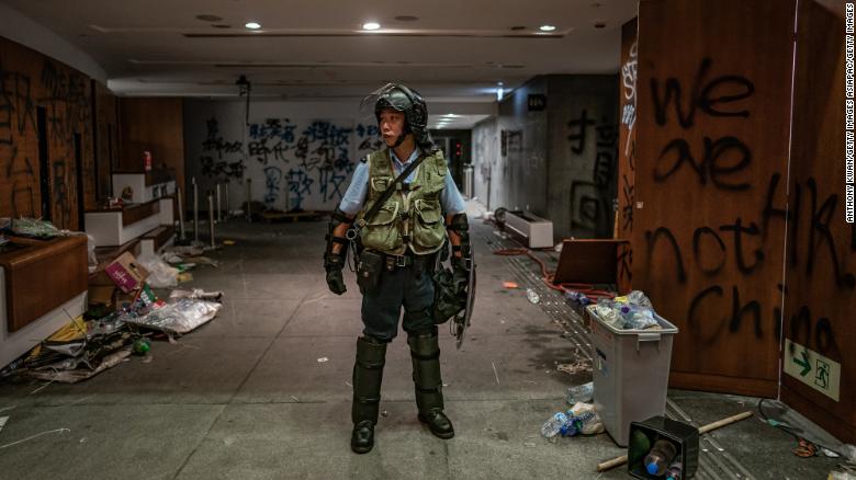 A riot police stands near graffiti inside the Legislative Council building after it was damaged by demonstrators during a protest on July 2 in Hong Kong.