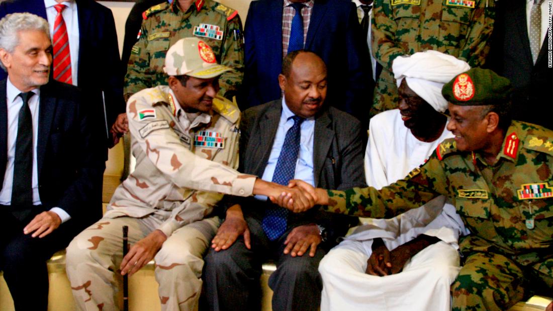 African Union envoy to Sudan Mohamed al-Hacen Lebatt, second from left, shakes hands with an army general following a press conference announcing an agreement was reached. Under the terms, the military council will be in charge of the country&#39;s leadership for the first 21 months. A civilian administration will rule the council during the following 18 months.