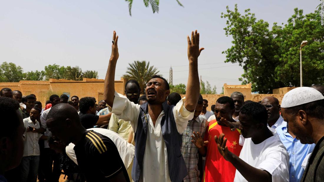 Relatives of three Sudanese men who were found dead with bullet wounds mourn near their bodies in the city of Omdurman on July 1.