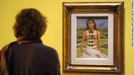 A visitor looks at the painting &quot;The Broken Column&quot; by Frida Kahlo at the Martin-Gropius-Bau museum in Berlin.