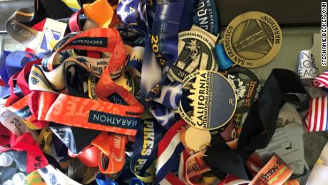 A pile of Meza's racing medals rests on a coffee table at home.