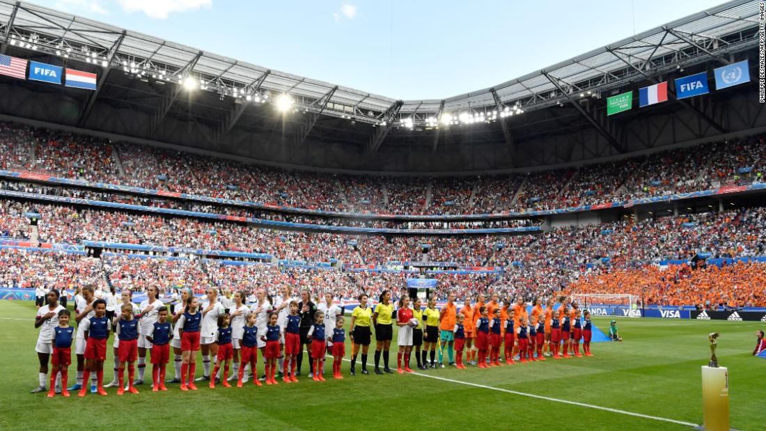 The teams stand for their national anthems before the match.