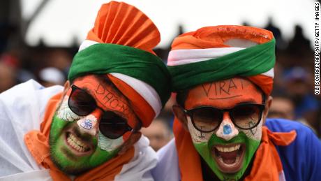 Indian supporters with faces painted in the national colours pose for a photograph.
