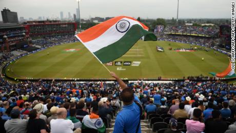 An Indian supporter waves the national flag high up in the stands as the teams come out.