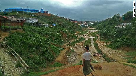 A Rohingya man walks through the refugee camp to his home before another round of rain. 