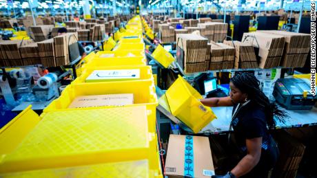 A woman works at a packing station at the 855,000-square-foot Amazon fulfillment center in Staten Island, one of the five boroughs of New York City, on February 5, 2019. - Inside a huge warehouse on Staten Island thousands of robots are busy distributing thousands of items sold by the giant of online sales, Amazon. (Photo by Johannes EISELE / AFP)        (Photo credit should read JOHANNES EISELE/AFP/Getty Images)