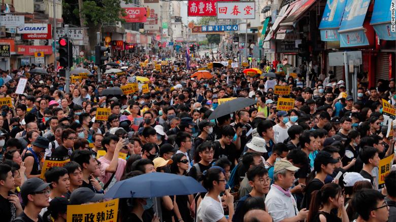 Protesters with placards reading "Strictly enforce the law, stop cross-border traders," march in an area popular with Chinese tourists for its pharmacies and cosmetic shops, in Hong Kong, Saturday, July 13.