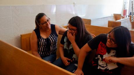 Francisca Lino, left, talks and laughs with her twin 17-year-old daughters Judith, center, and Juliana, right.