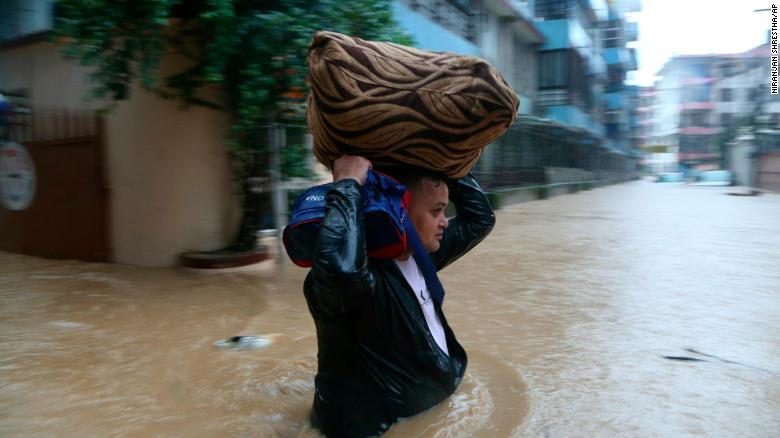 A Nepalese man wades through a flooded street in Kathmandu, Nepal, on July 12, 2019.