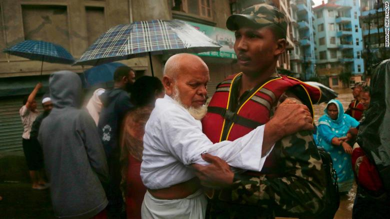 A Nepalese soldier moves an elderly man to a safer area in Kathmandu on July 12, 2019. 