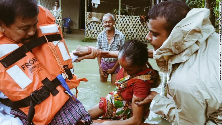 India's National Disaster Response Force evacuate people in flooded parts of Assam state.