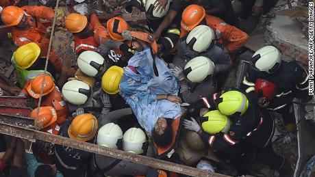 Emergency personnel rescue a survivor from the rubble.