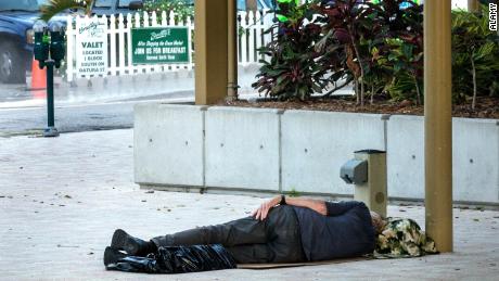 A man sleeps by the Great Lawn and Lake Pavilion in downtown West Palm Beach.