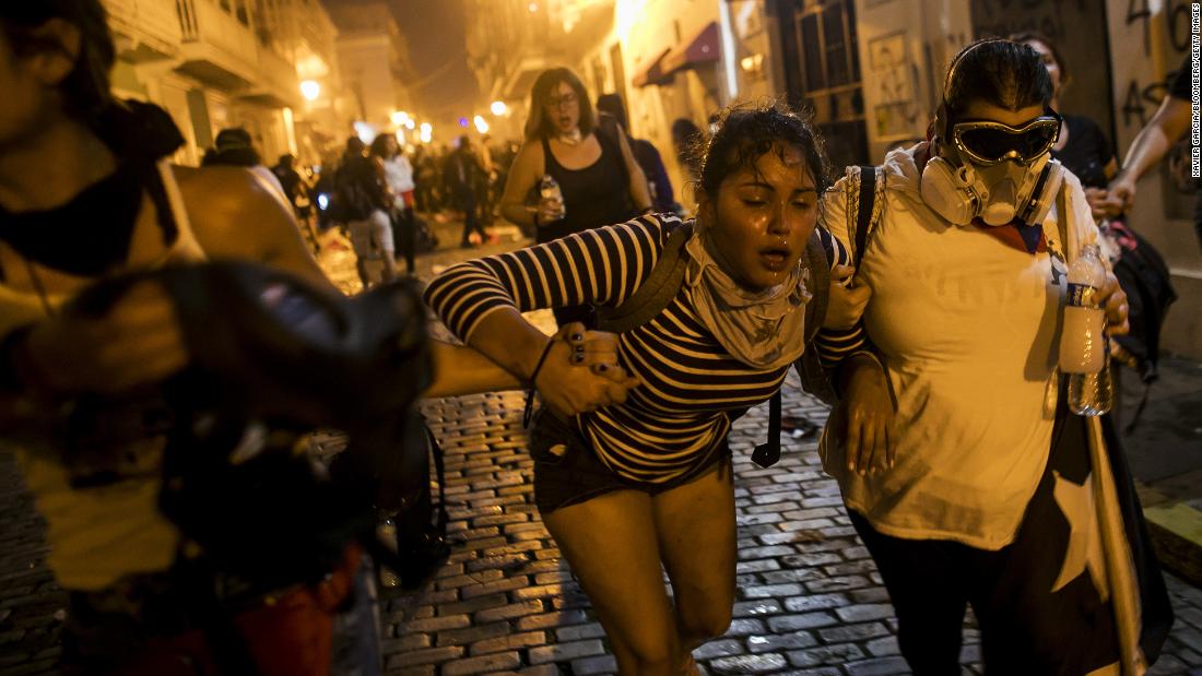 A woman is assisted in the streets after demonstrators clashed with police on Wednesday, July 17.