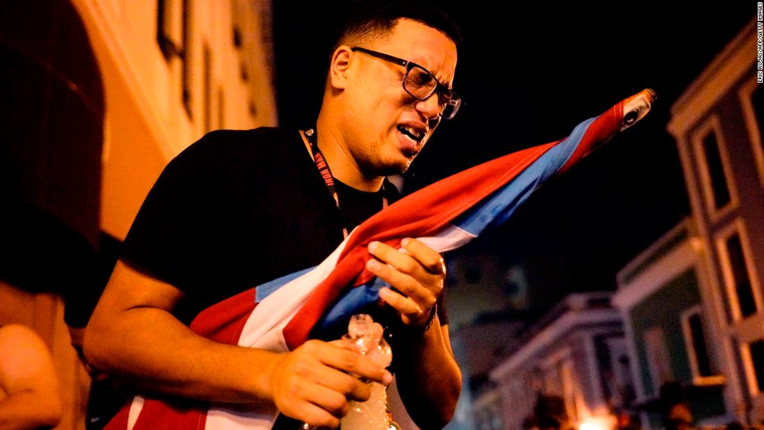 A protester reacts after being sprayed by tear gas in San Juan.