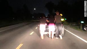 Aeron McQuillin, Bailey Campbell, Billy Tarbett push a stranded motorist's car home.