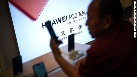 A customer looks at a smartphone at a Huawei retail store in Beijing on May 23, 2019. - Chinese telecom giant Huawei says it could roll out its own operating system for smartphones and laptops in China by the autumn after the United States blacklisted the company, a report said on May 23. (Photo by FRED DUFOUR / AFP)        (Photo credit should read FRED DUFOUR/AFP/Getty Images)
