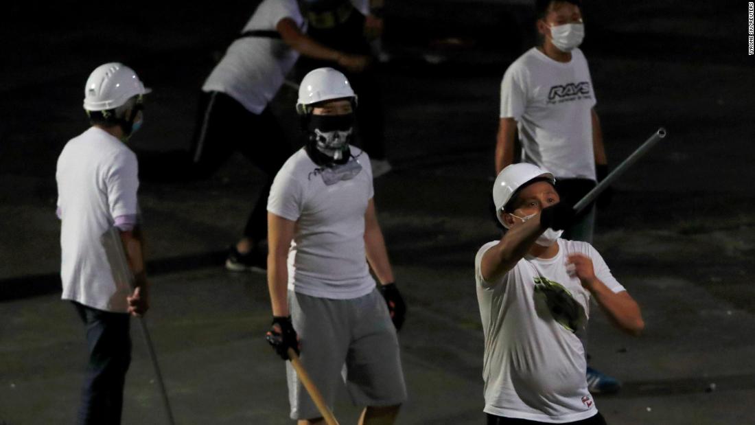 Masked men in white T-shirts are seen after &lt;a href=&quot;https://edition.cnn.com/2019/07/23/asia/hong-kong-triad-arrests-intl-hnk/index.html&quot; target=&quot;_blank&quot;&gt;attacking anti-extradition bill demonstrators&lt;/a&gt; at a train station in Yuen Long.