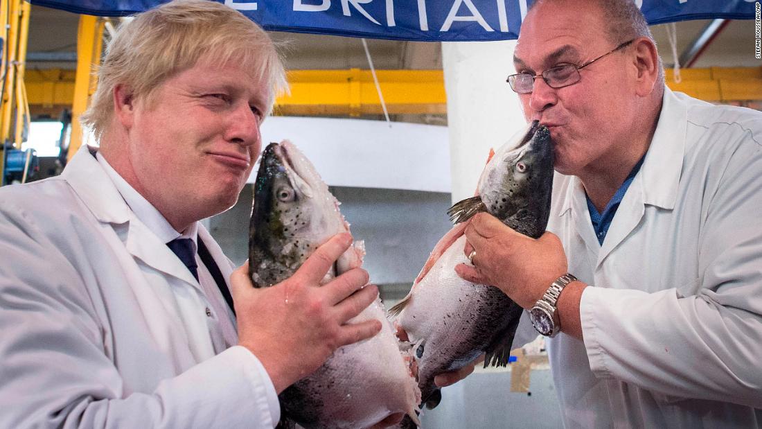 Johnson kisses a wild salmon while visiting a fish market in London in June 2016. A month earlier, he stepped down as mayor but remained a member of Parliament for Uxbridge and South Ruislip.