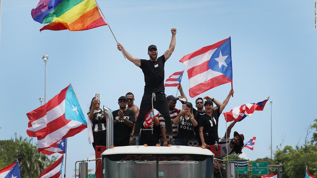 Puerto Rican pop star Ricky Martin, waving a rainbow flag, joins the protests on Monday. Members of the group chat that Rosselló took part in made vulgar references to the star&#39;s sexuality.