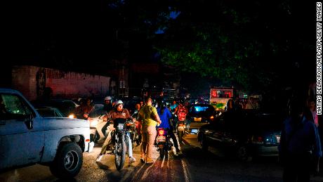 People on cars, motorbikes and on foot crowd in Caracas after Venezuela was hit by a massive power cut on July 22, 2019. 