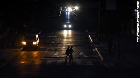 People crossing a street in Caracas on July 22, 2019 as the capital and other parts of Venezuela are being hit by a massive power cut.