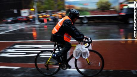 A delivery man rides his bike in the rain to deliver food in New York on November 17, 2014. The coldest air since last winter is set to move into the East during the first few days of the week, with high temperatures from Washington, DC, through New York City forecast to stay near or below freezing 32F (0C) on Tuesday, levels that would be considered below normal even during the heart of winter. AFP PHOTO/Jewel Samad        (Photo credit should read JEWEL SAMAD/AFP/Getty Images)