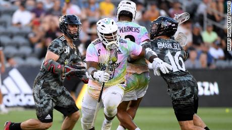 Trevor Baptiste #9 of Team Baptiste carries the ball between Mark Glicini #16 and Jake Frocarro #54 of Team Rambo during the Premier Lacrosse League All-Star game.