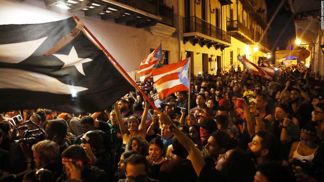 Puerto Ricans wave flags in celebration of Rosselló&#39;s resignation.