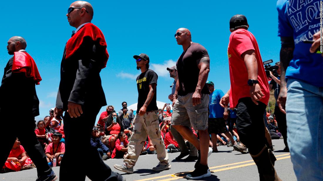 Actor Dwayne "The Rock" Johnson, third from right, walks with telescope protesters during his visit to the base of Mauna Kea.