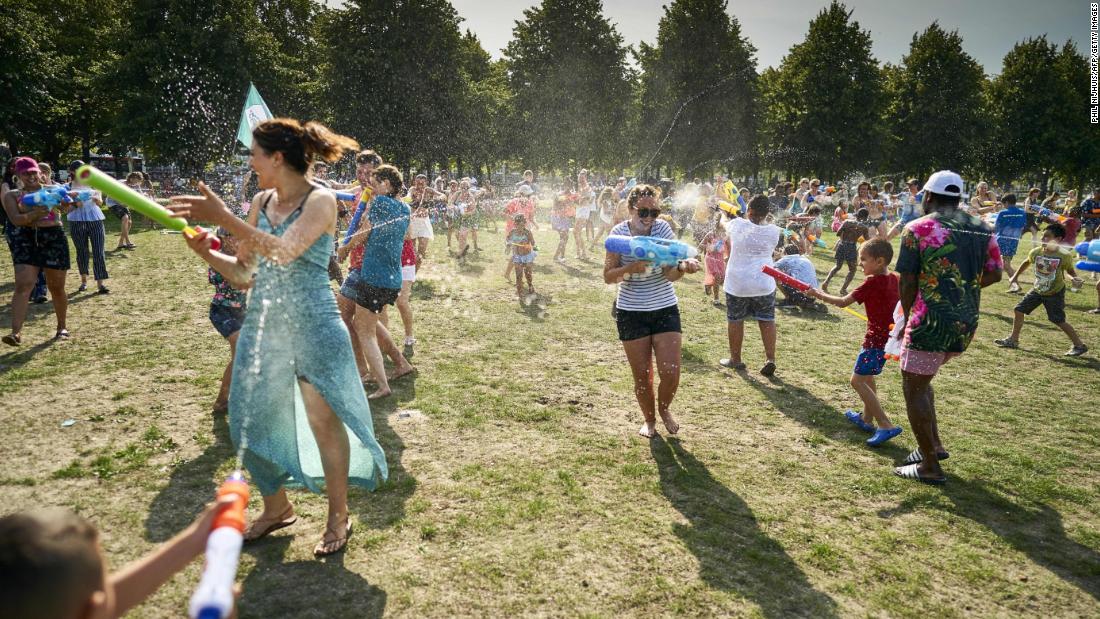 People cool off with a water fight at a park in The Hague, Netherlands, on Wednesday, July 24.