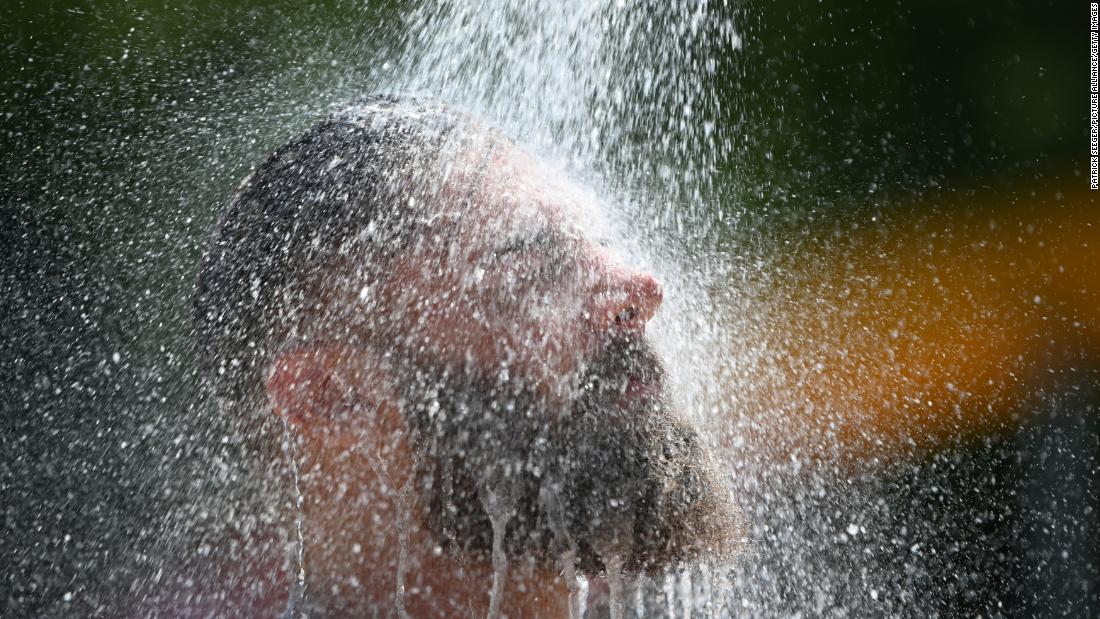 A man cools down at an outdoor pool's shower in Baden-Wuerttemberg, Germany, on Thursday, July 25.