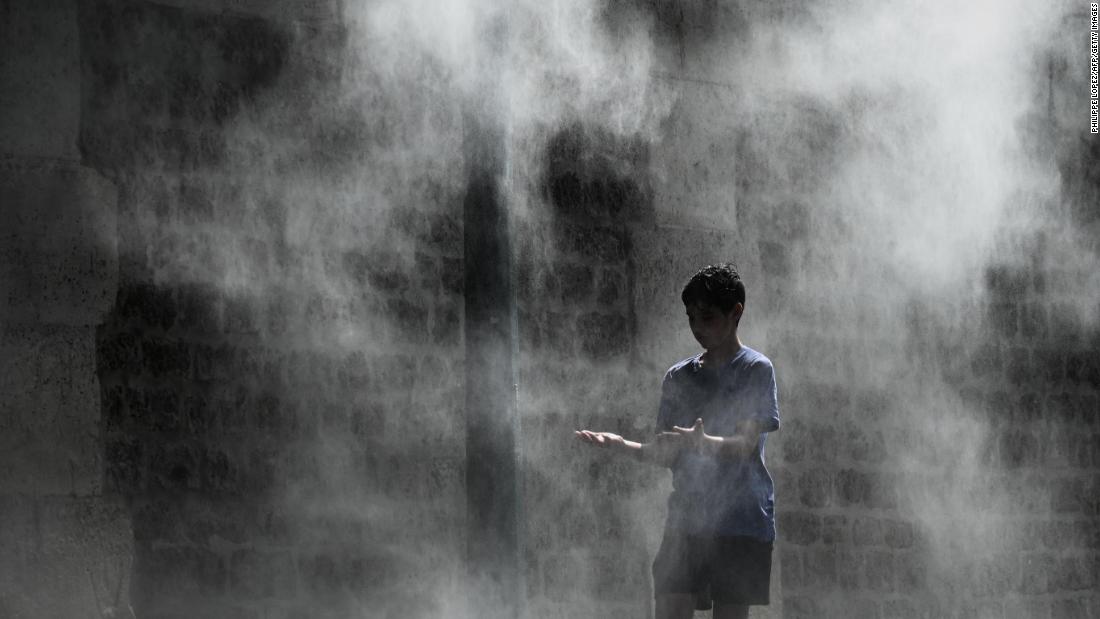 A boy cools off under a public water spray on the bank of the Seine river in Paris on Thursday, July 25.