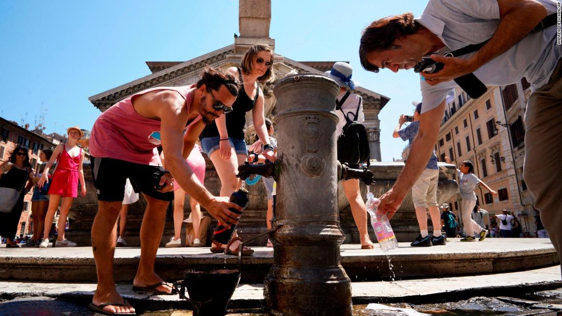 People collect water from the public fountain in front of the Pantheon in Rome on Thursday, July 25.