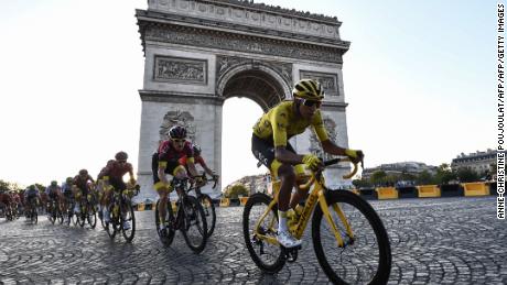 Colombia&#39;s Egan Bernal rides down the Champs Elysees alongside the Arc de Triomphe.