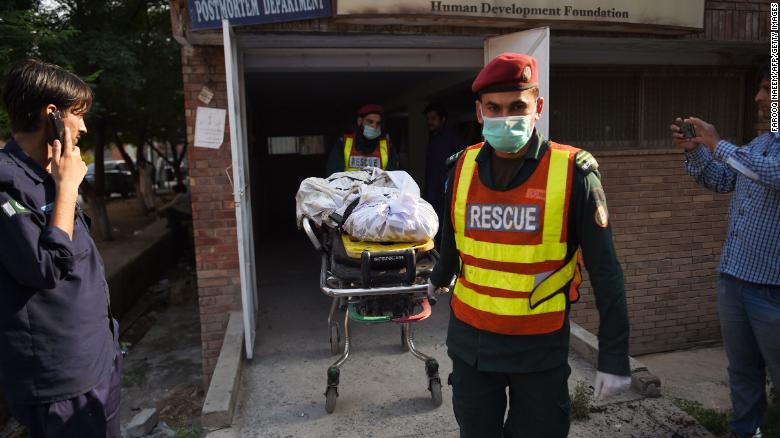 The body of a victim, killed after a Pakistani Army Aviation Corps aircraft crashed into residential buildings, is wheeled on a stretcher at hospital in Rawalpindi on July 30.